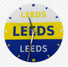 A circular wall clock featuring the Leeds club colors, with a white top half, yellow middle band, and blue bottom half, all printed with the word 'LEEDS'. The clock has silver hands and small blue and white hour markers.