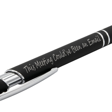 A dark gray ballpoint pen with silver trim and white script text reading 'This Meeting Could Be Fun on Email', resting on a textured dark gray surface.