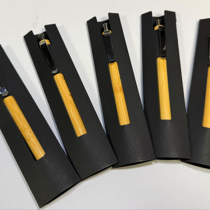 Five yellow-handled tools with black metal heads are displayed in matching black protective sleeves on a white surface.