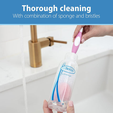 Cleaning brush with pink bristle head held by a hand over a sink, with text 'Thorough cleaning with combination of sponge and bristles'.