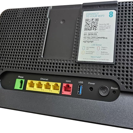 A black wireless router with a built-in cooling fan on the top panel, featuring multiple Ethernet ports, a USB port, and a power/reset button on the front base.