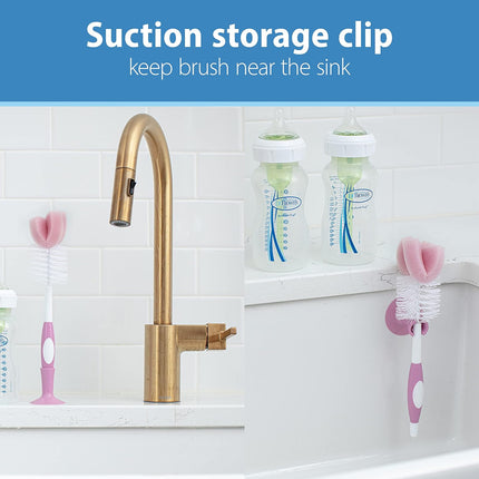 Suction storage clip for baby bottles near a sink with a gold faucet.