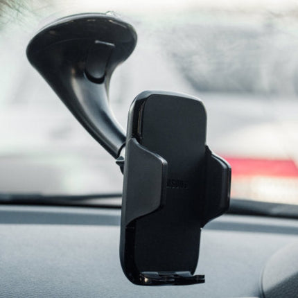 A black car windshield phone mount with a suction cup, attached to a dashboard inside a vehicle.