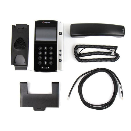 A black and white Polycom conference phone system kit laid out on a white background, including the main phone unit, handset, coiled cord, base, and mounting bracket.