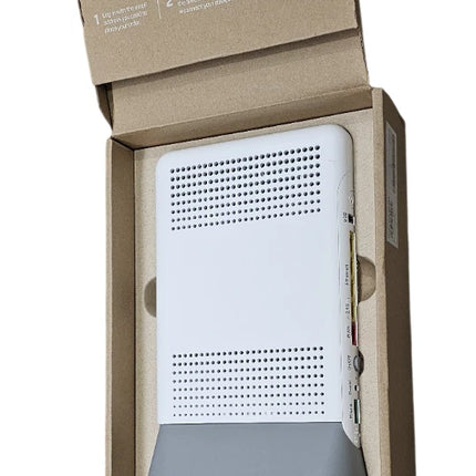 A white electronic device with a gray base, presented inside an open brown cardboard box with accessories including a power adapter and cables.