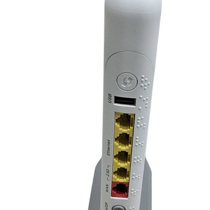 A white wireless router with five yellow and one red Ethernet ports, standing on a gray base against a white background.